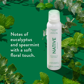 Native deodorant spray with text saying "Notes of eucalyptus and spearmint with a soft floral touch", styled with eucalyptus and mint leaves