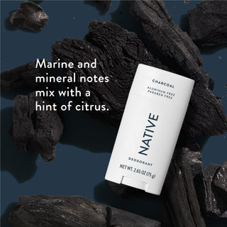 Native deodorant with text saying "Marine and mineral notes mix with a hint of citrus", styled with charcoal pieces in background