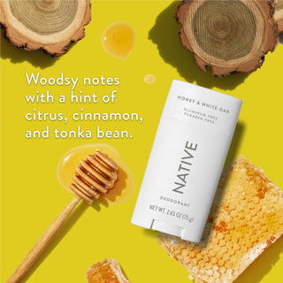 Native deodorant with text saying "Woodsy notes with a hint of citrus, cinnamon, and tonka bean", styled with honey combs and white oak pieces