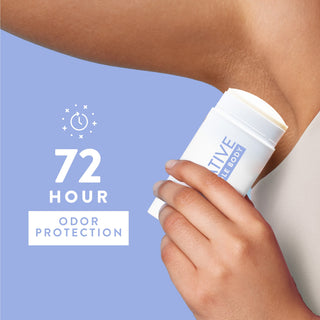 Woman spraying Native Cotton & Lily Whole Body Deodorant under arm, wearing a white tank top