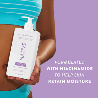 Woman holding Native Lilac & White Tea Moisturizing Lotion bottle with text reading "Formulated with niacinamide to help skin retain moisture"