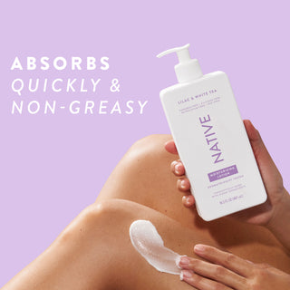 Native Lilac & White Tea Moisturizing Lotion bottle being applied to a person's leg, promoting “Absorbs quickly & non-greasy”