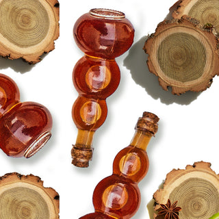 Bottle containing amber liquid next to wood pieces