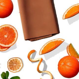 Arrangement with a leather piece, orange slices, and thin orange peel strips