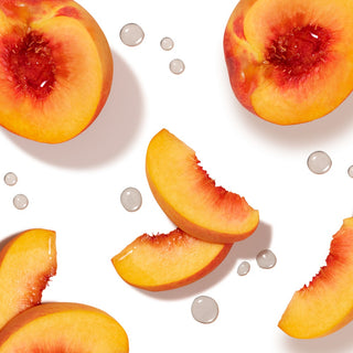 Peach slices and halved peaches next to water drops