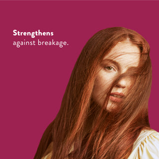 Woman with long red hair with text reading “Locks in moisture and helps strengthen against breakage”